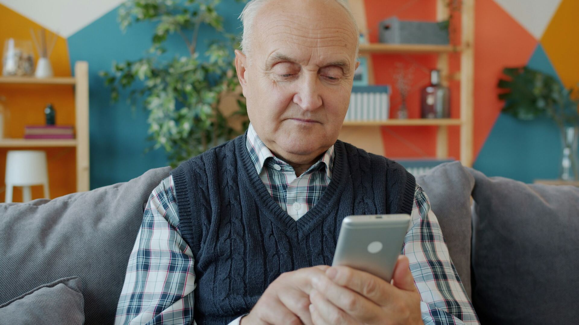 Personne âgée assise chez elle, répondant à un appel téléphonique