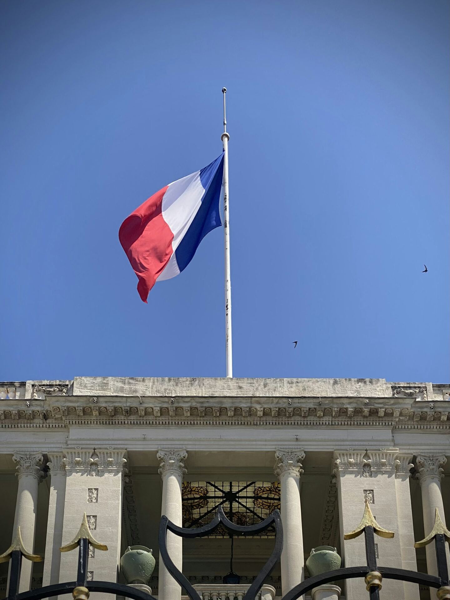 Drapeau français flottant devant la façade d’une mairie